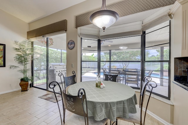 dining room with a wealth of natural light, ceiling fan, and light wood-type flooring