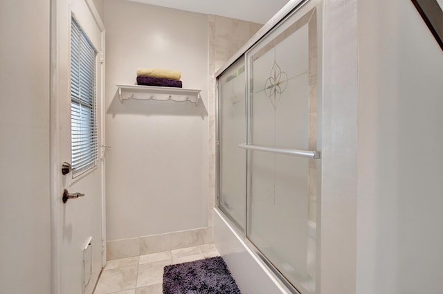 bathroom featuring tile patterned floors and shower / bath combination with glass door