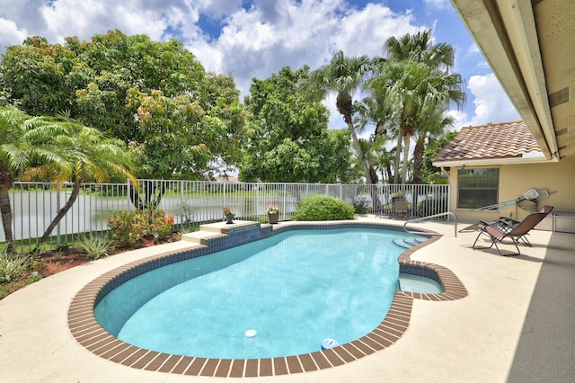 view of swimming pool featuring a patio area and a water view