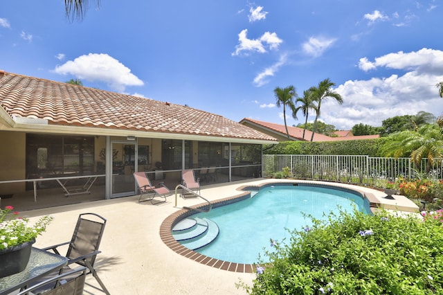 view of swimming pool featuring a sunroom and a patio