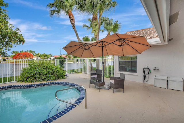 view of pool with a patio area and a water view