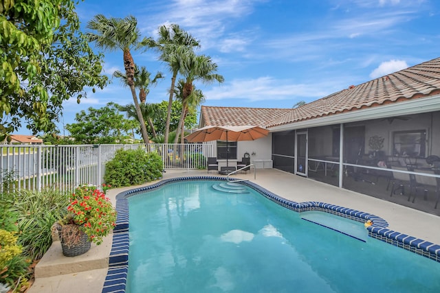 view of swimming pool featuring a sunroom and a patio