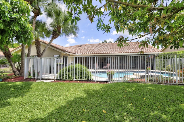 back of house with a fenced in pool and a lawn