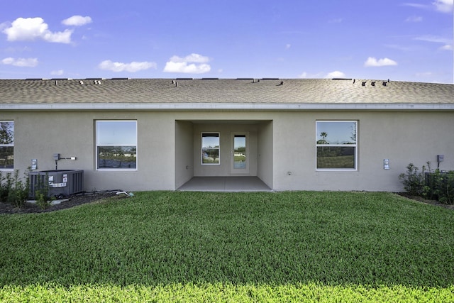 rear view of property featuring a patio area, a yard, and cooling unit