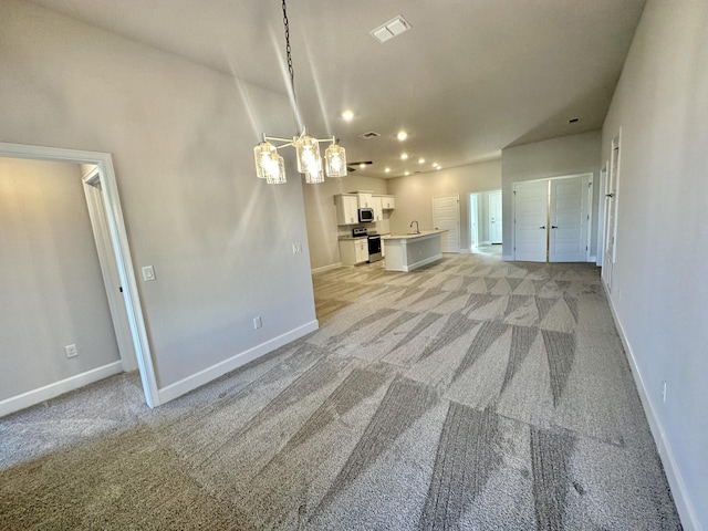 unfurnished living room featuring light colored carpet and sink