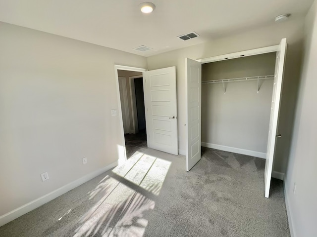 unfurnished bedroom with light carpet and a closet