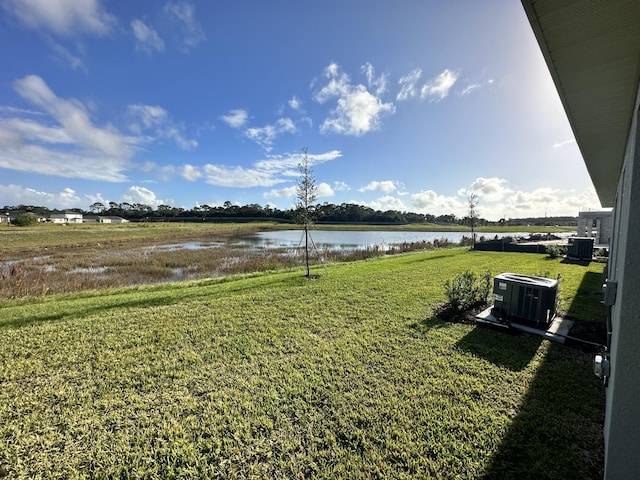 view of yard with a water view and central AC unit