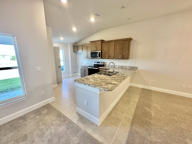 kitchen with stainless steel appliances, vaulted ceiling, plenty of natural light, and sink