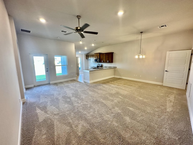 unfurnished living room with ceiling fan with notable chandelier, lofted ceiling, and light carpet