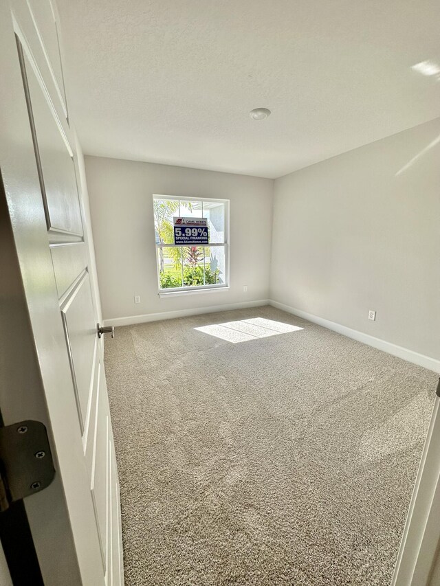 unfurnished living room with ceiling fan with notable chandelier, light colored carpet, and lofted ceiling