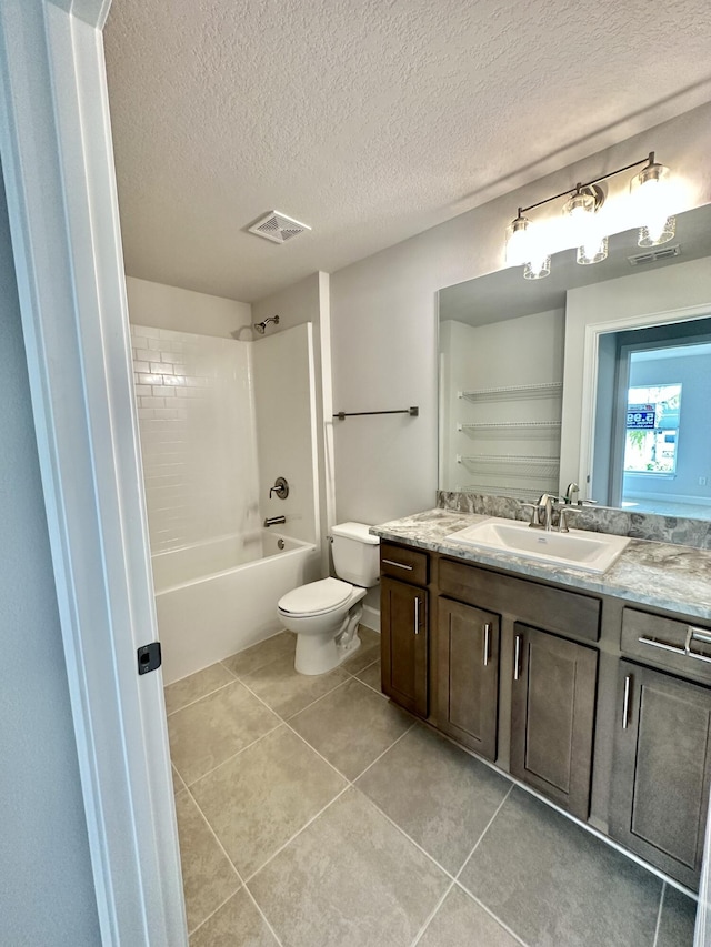 full bathroom featuring tile patterned flooring, tiled shower / bath, a textured ceiling, and toilet