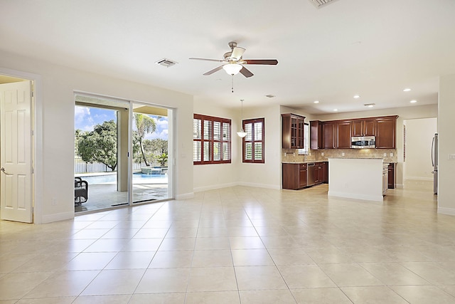 unfurnished living room with light tile patterned floors, baseboards, visible vents, and a ceiling fan