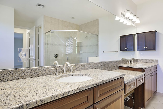 bathroom with an enclosed shower, vanity, and tile patterned flooring