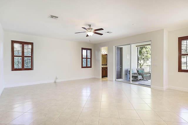 tiled empty room featuring a wealth of natural light and ceiling fan