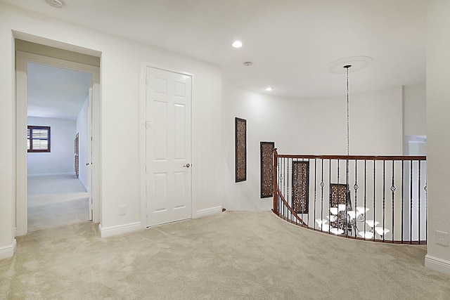 hall with carpet floors, recessed lighting, baseboards, and an upstairs landing