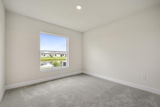 carpeted spare room with a water view