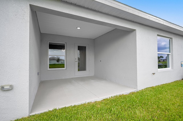 doorway to property featuring a yard and a patio