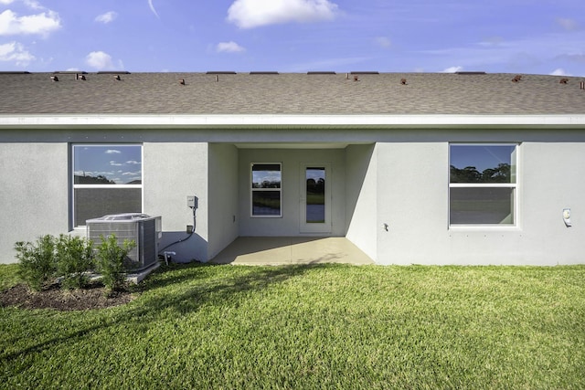 rear view of property featuring a patio, a yard, and central AC