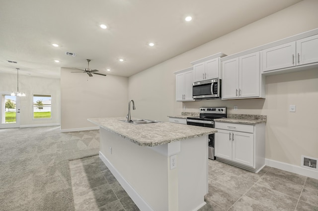 kitchen featuring a center island with sink, white cabinets, sink, ceiling fan, and appliances with stainless steel finishes