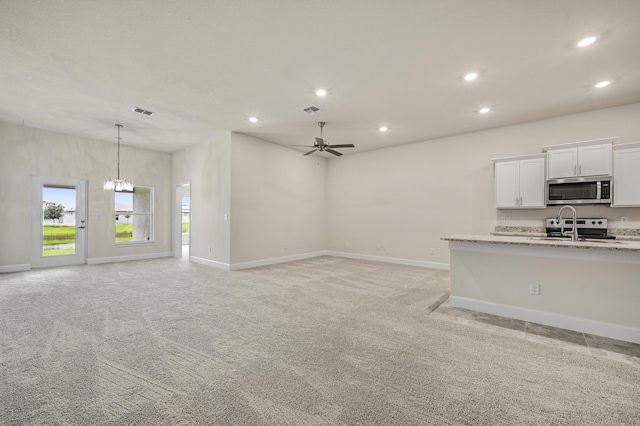 kitchen featuring white cabinets, appliances with stainless steel finishes, a center island with sink, and sink