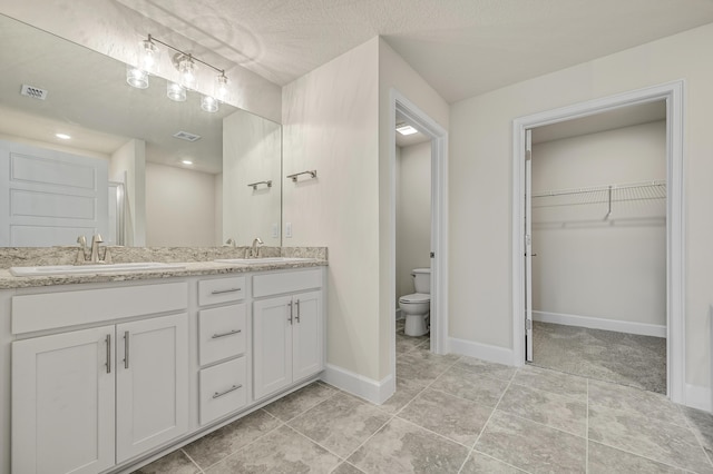 kitchen with light stone countertops, sink, stainless steel appliances, white cabinets, and ceiling fan with notable chandelier