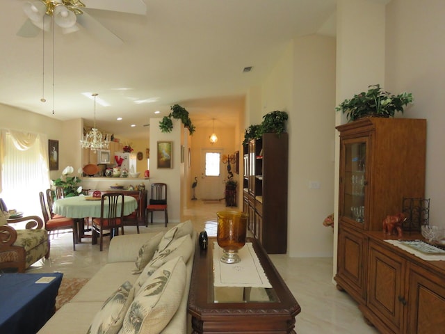 living room featuring ceiling fan with notable chandelier