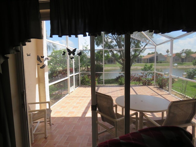 sunroom / solarium featuring a water view