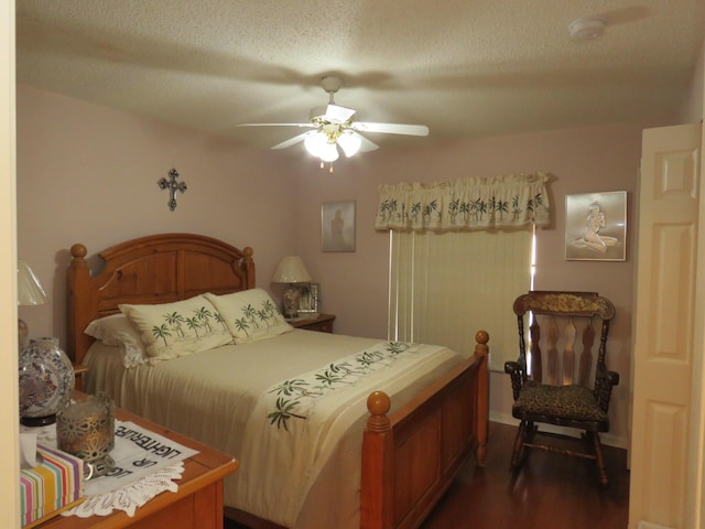 bedroom with a textured ceiling, dark hardwood / wood-style flooring, and ceiling fan