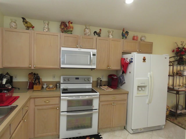 kitchen featuring light brown cabinets, light tile patterned floors, and white appliances