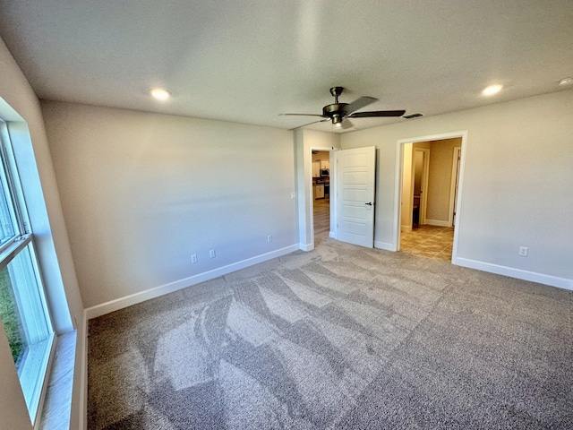 carpeted spare room with ceiling fan