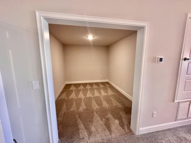 kitchen with white cabinets, a center island with sink, light stone counters, appliances with stainless steel finishes, and light colored carpet