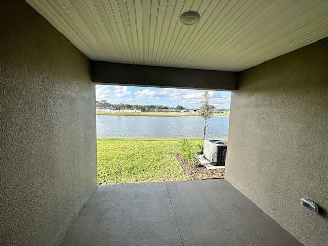 view of patio featuring cooling unit and a water view