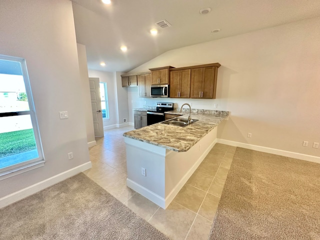 kitchen with kitchen peninsula, appliances with stainless steel finishes, sink, light tile patterned floors, and lofted ceiling