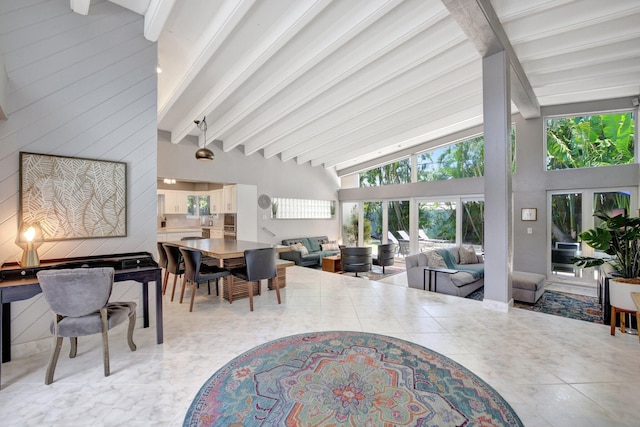 living room featuring beamed ceiling, french doors, and high vaulted ceiling