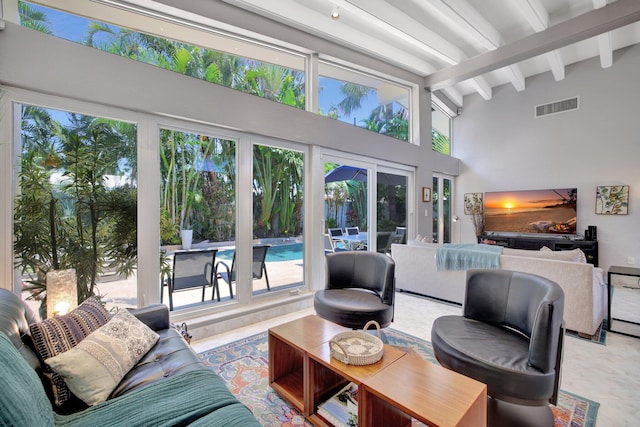 tiled living room with beam ceiling, french doors, and high vaulted ceiling