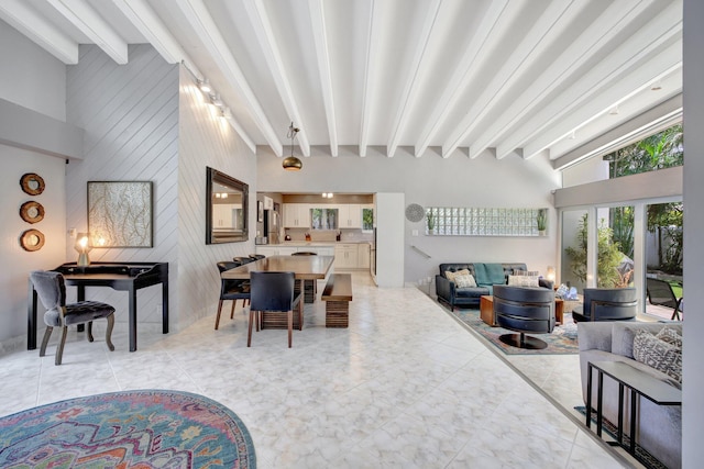 living room with beamed ceiling and high vaulted ceiling