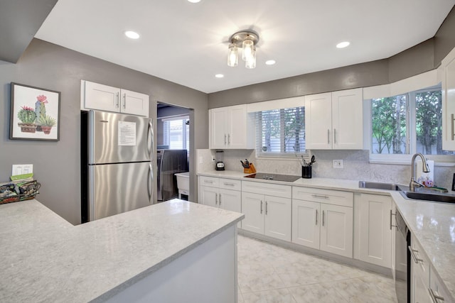 kitchen with decorative backsplash, sink, white cabinets, and appliances with stainless steel finishes