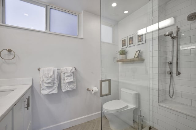 bathroom featuring vanity, a shower with shower door, and toilet