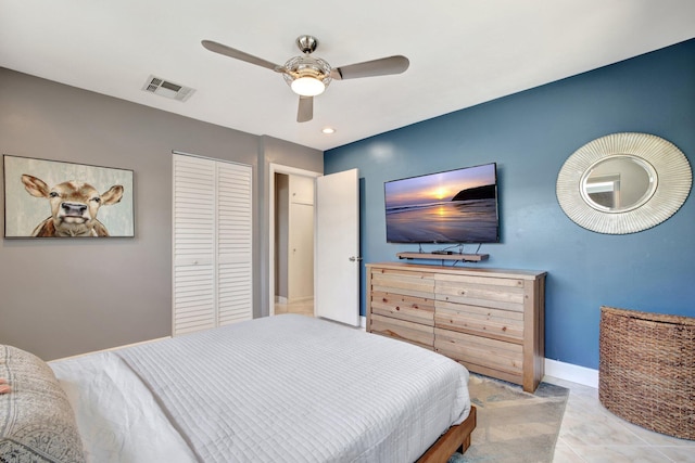 bedroom featuring ceiling fan, light tile patterned floors, and a closet