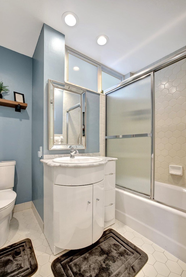 full bathroom with tile patterned flooring, combined bath / shower with glass door, toilet, and vanity