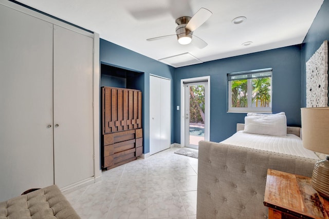 bedroom featuring ceiling fan, access to exterior, and multiple closets