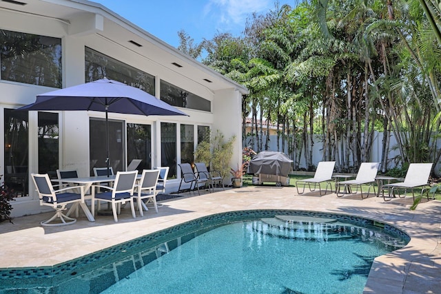 view of swimming pool featuring a grill and a patio area