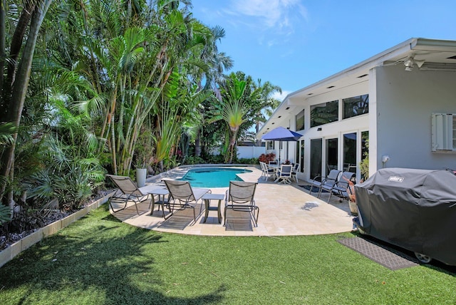 view of swimming pool with a lawn, a grill, and a patio