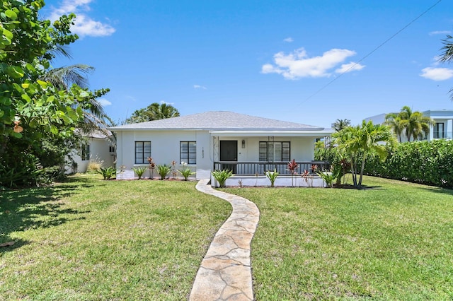 view of front of house with covered porch, a front lawn, and stucco siding