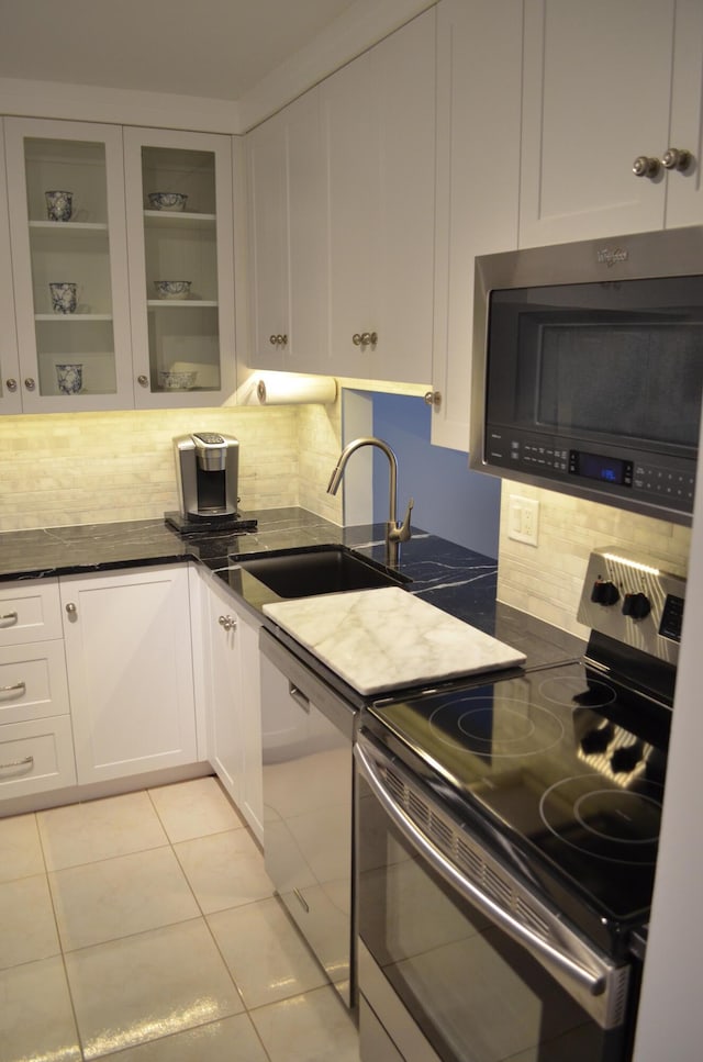 kitchen featuring sink, white cabinetry, stainless steel appliances, and light tile patterned floors