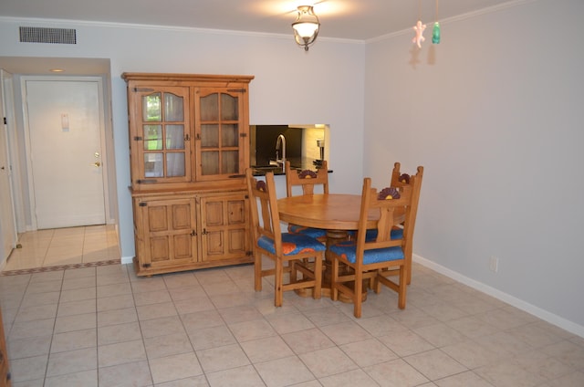 tiled dining room featuring ornamental molding