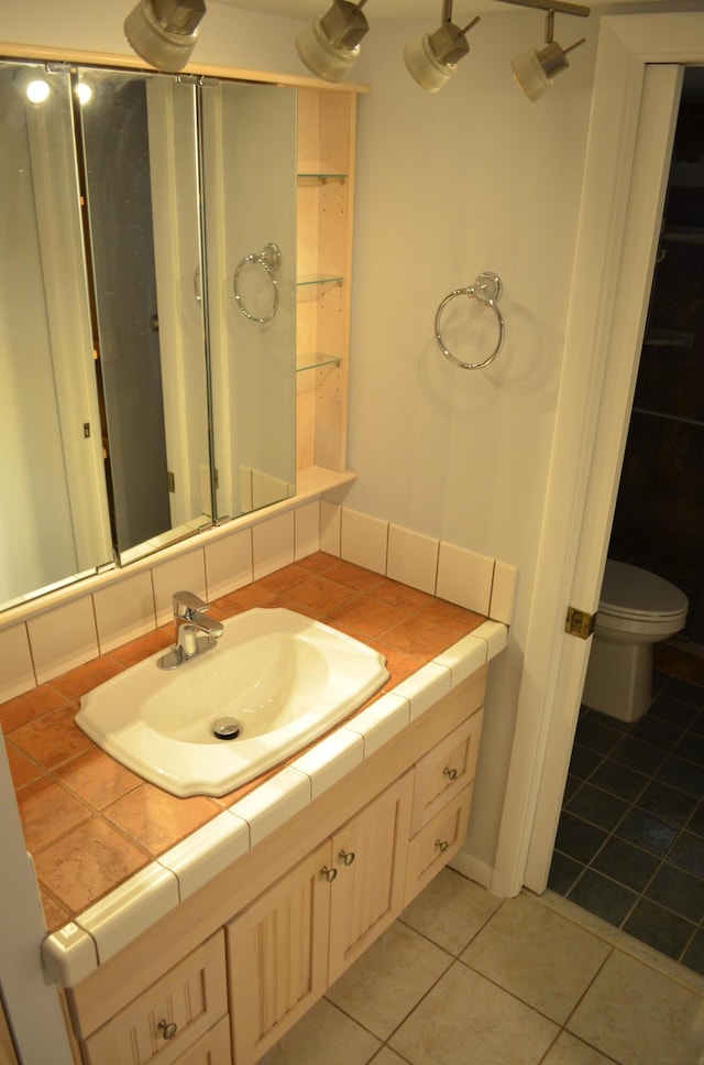 bathroom featuring tile patterned flooring, vanity, and toilet