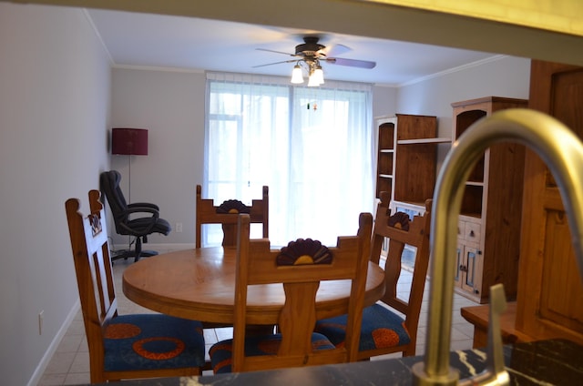 tiled dining room with ceiling fan and ornamental molding