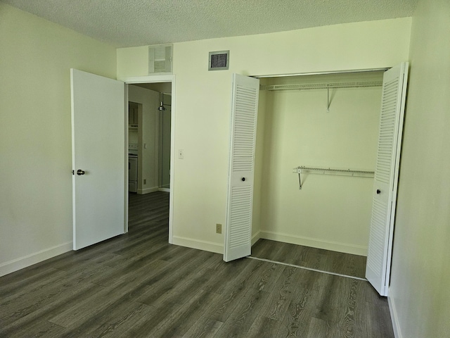 unfurnished bedroom featuring dark hardwood / wood-style floors, a closet, and a textured ceiling