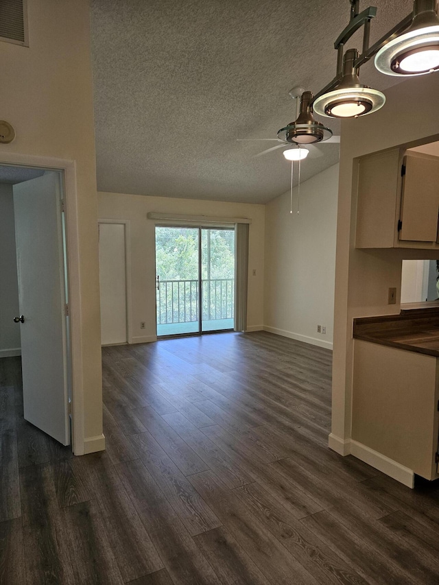 unfurnished living room featuring ceiling fan, dark hardwood / wood-style floors, and a textured ceiling